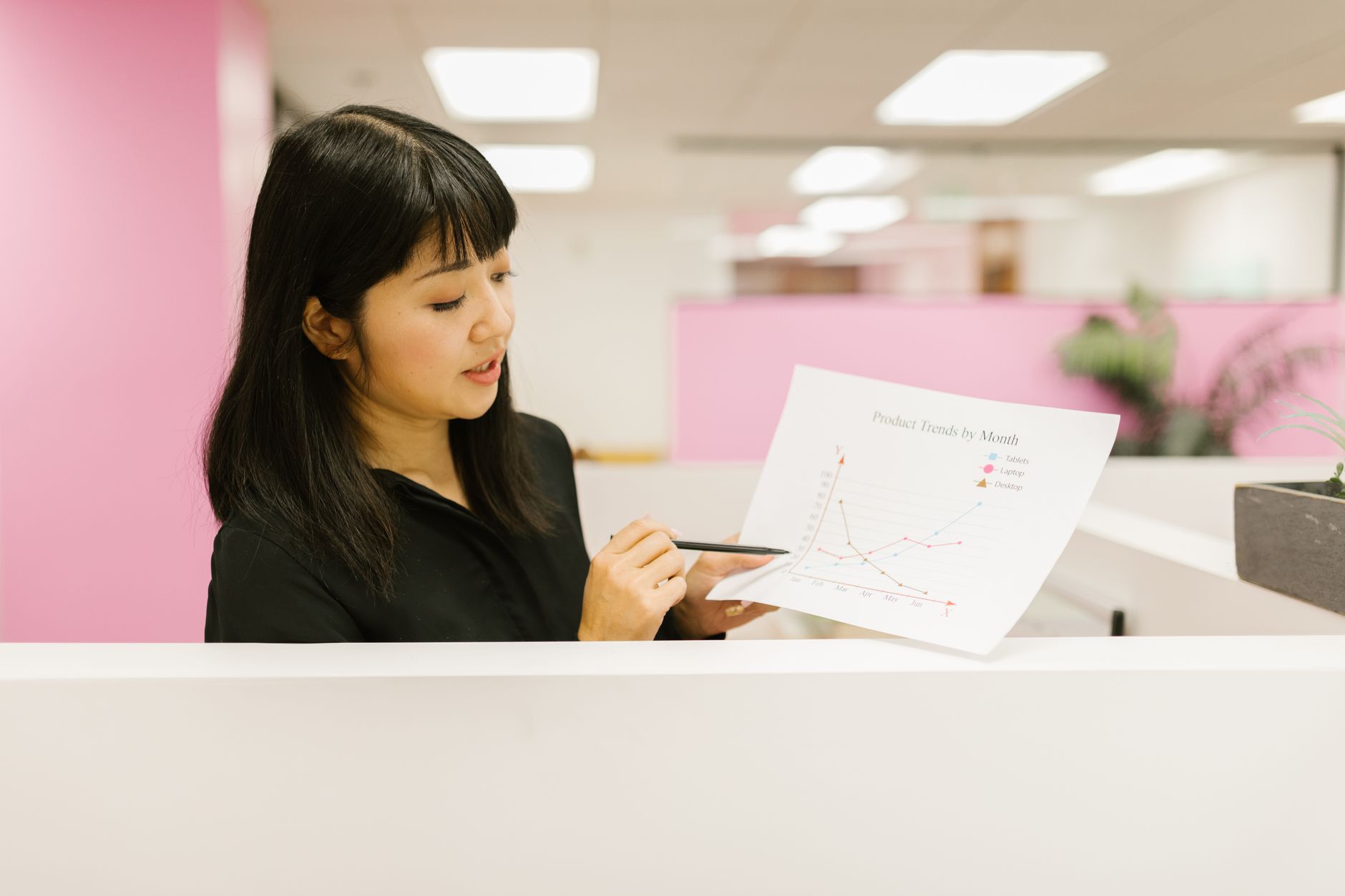 A modern office setting in Jakarta with a professional data analyst working on complex data visualizations across multiple monitors.