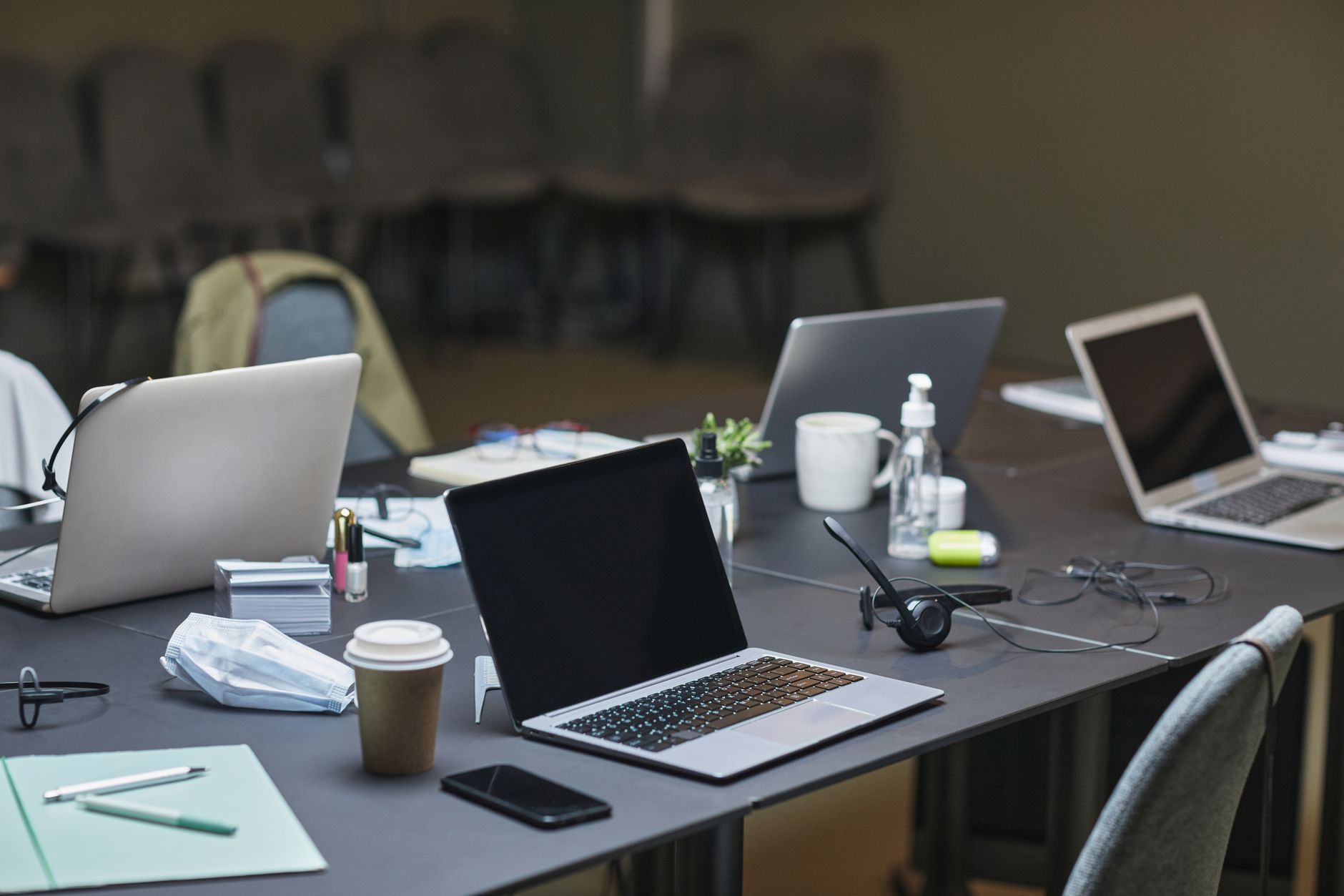 A professional boardroom setting with a laptop showing a security shield icon and a digital map of Southeast Asia on the wall.