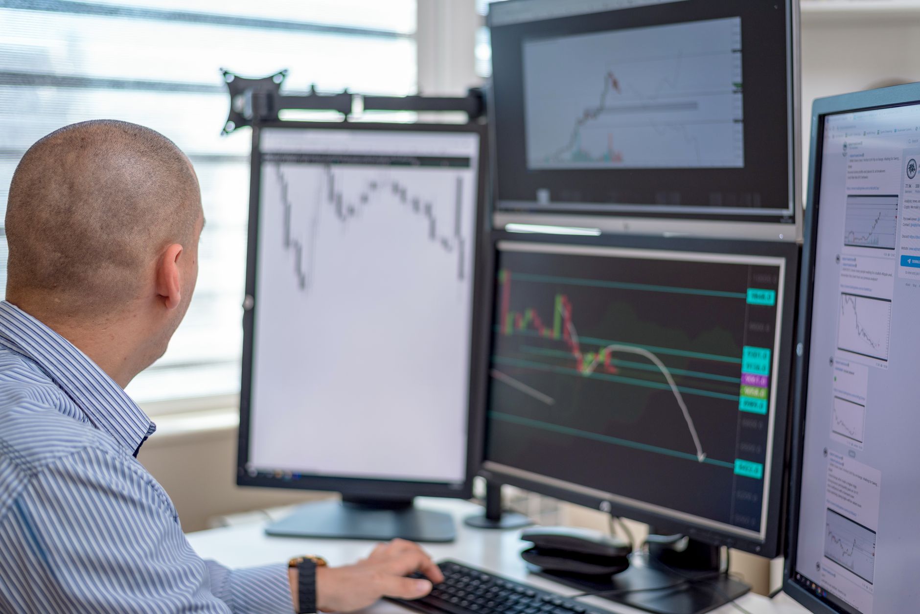 A professional workspace with multiple monitors displaying data dashboards and workflow automation diagrams, representing modern business operations.