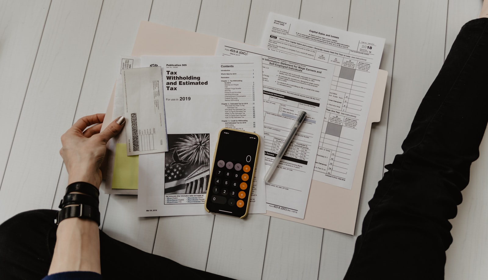 A calculator, notebook and pen on a desk
